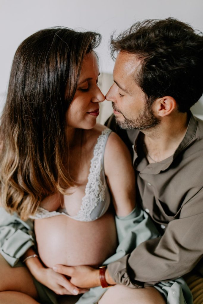 Expecting parents are cuddling close and touching noses. Journey to parenthood shoot. Capturing the glow session. Hampshire photographer. Ewa jones photography