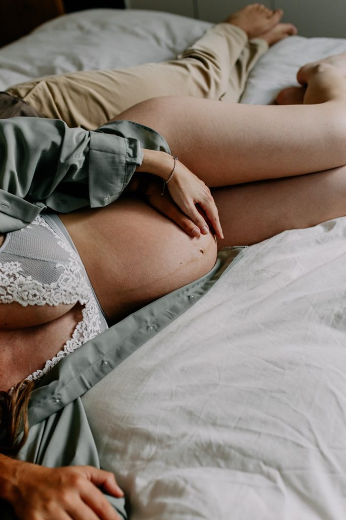 mum and dad are laying on bed and cuddling. Relaxed maternity photography at home. Hampshire photo shoot. Hampshire photographer. Basingstoke photographer. Ewa jones Photography