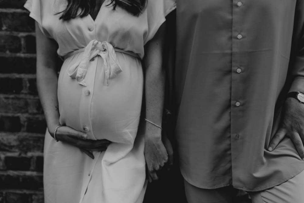 close up of baby bump and parents holding hands. Relaxed maternity photography. Hampshire photographer. Ewa jones photography