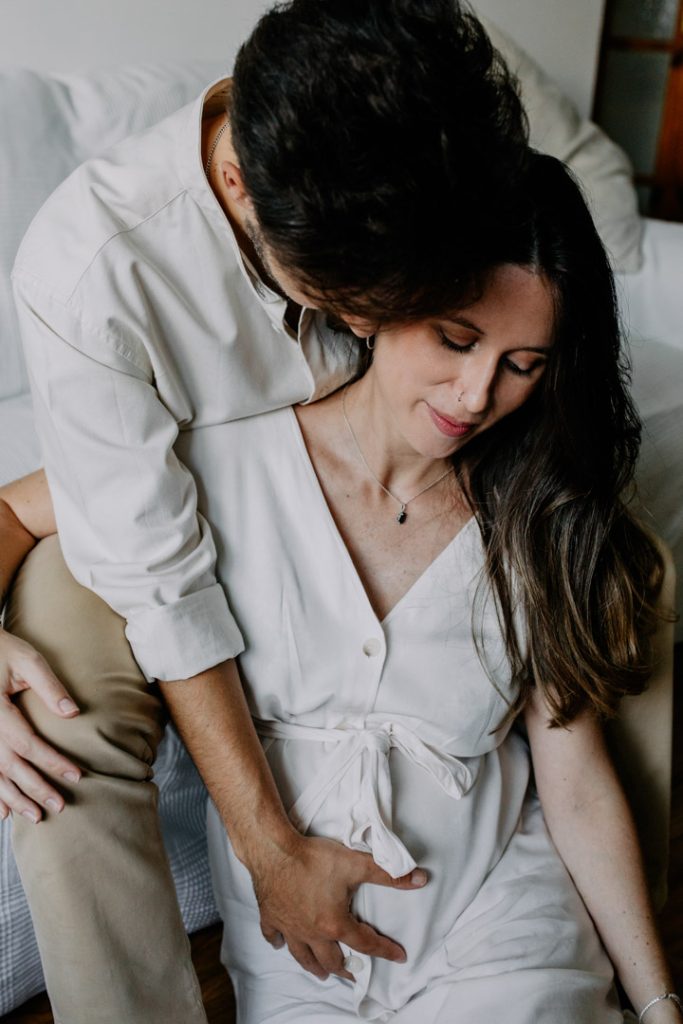 mum and dad to be are cuddling close. Exciting waiting for baby session. Natural photo session. In home pregnancy session. Hampshire photographer. Ewa Jones Photography