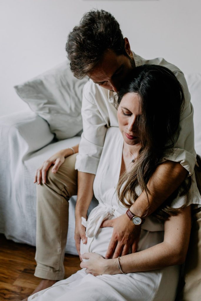 Mum and dad to be are cuddling close. Capturing the glow session. Pregnancy photo session. In home photo session. Hampshire photographer. Ewa Jones Photography