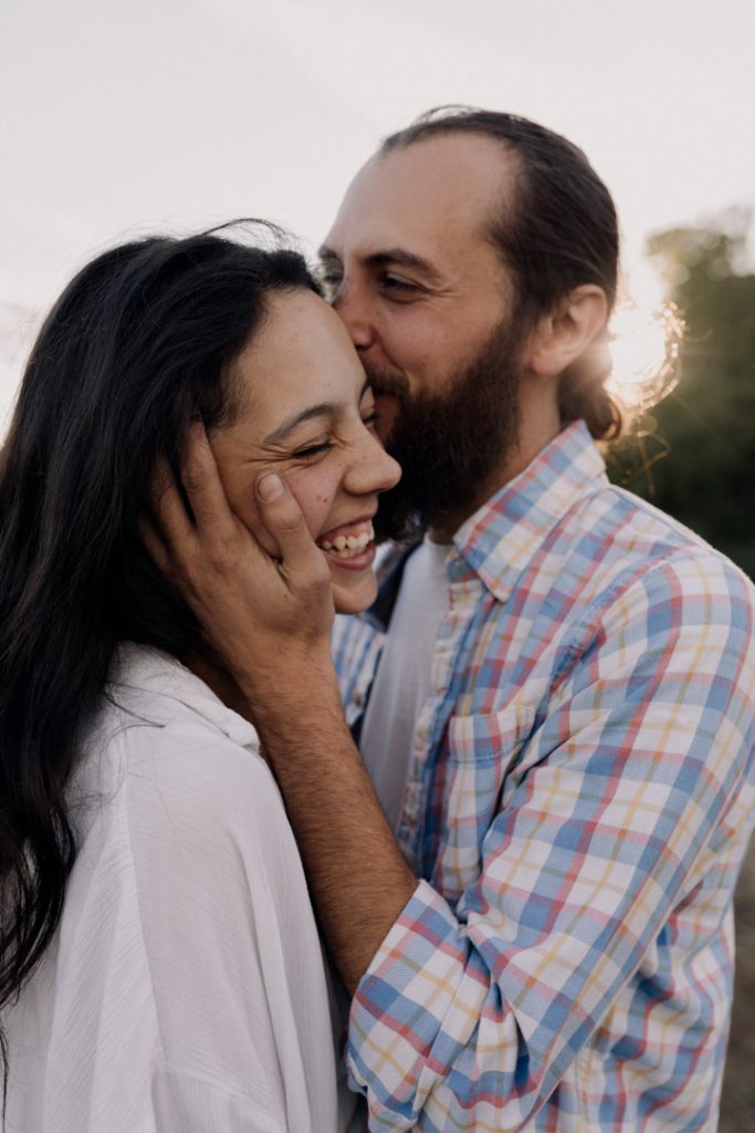 Man is kissing his partner. Couple photo shoot in Hampshire. Natural and intimate couple photo shoot. great time for couple photo session in Hampshire. Summer photo shoot. Hampshire photographer. Ewa Jones Photography