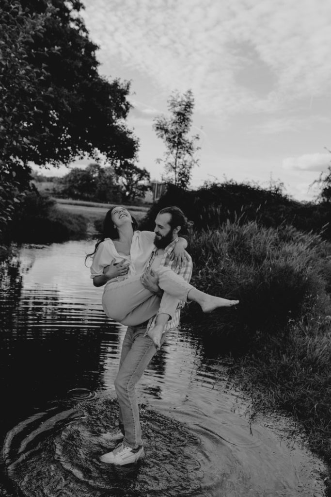 couple is in the water and man is lifting his partner. Genuine smiles of happiness. Couple's photo shoot. Hampshire photographer. Ewa Jones Photography