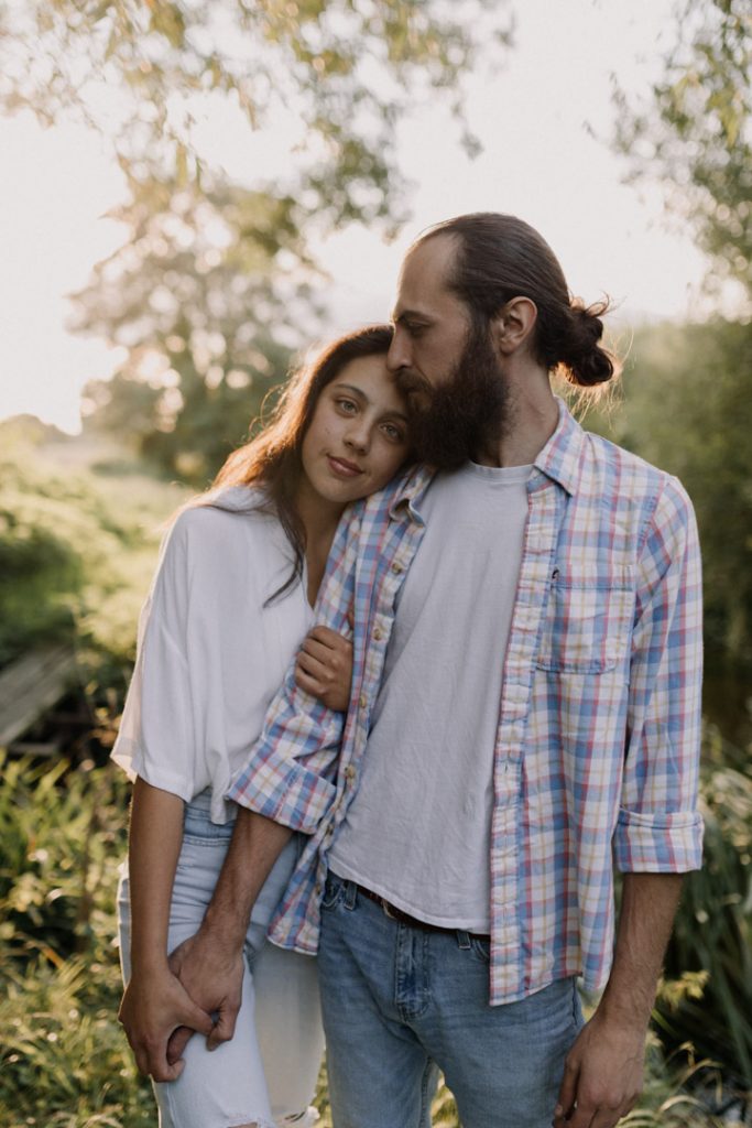 Couple is standing and being quiet and content. The sun is behind them. They are relaxed and happy with each other. Natural moment giving you feeling of peace and happiness. Hampshire photographer. Ewa Jones Photography