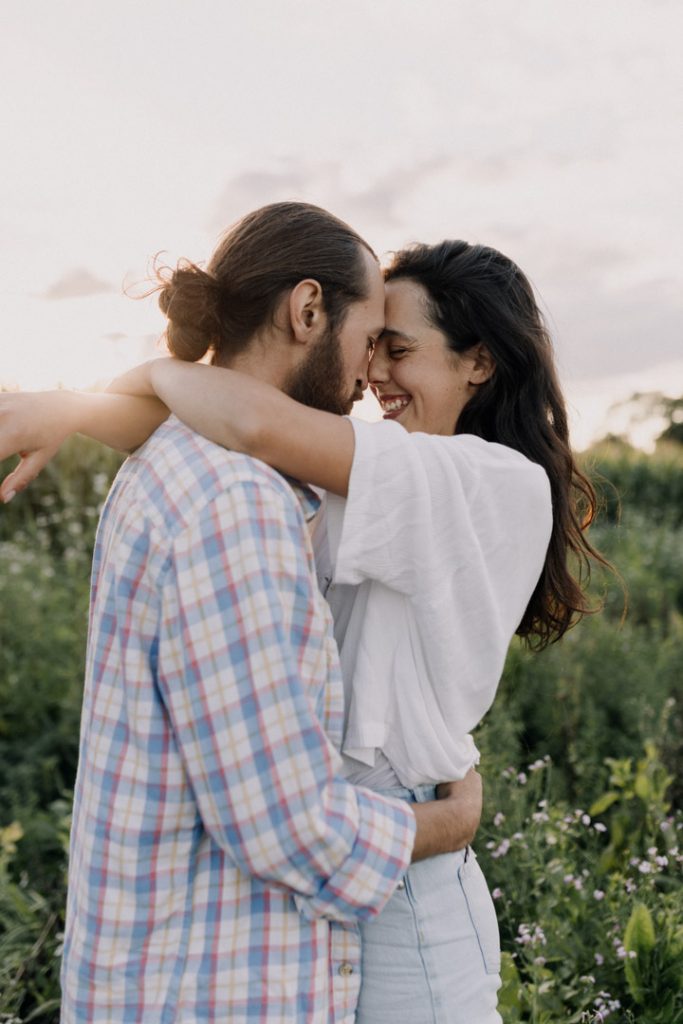 Female and male are cuddling close and smiling to each other. Natural photo session outdoors. Golden hour photo shoot. Hampshire photographer. Ewa Jones Photography