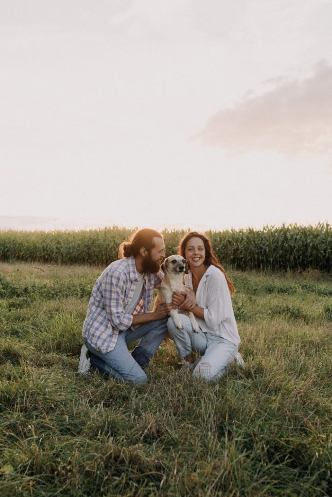 Couple is cuddling with their dog and smiling. Couples photo session in Hampshire. Hampshire photographer. Ewa Jones Photography