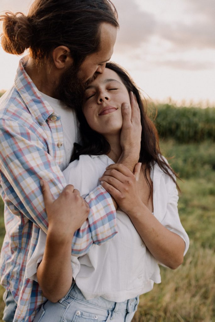 Female and male are cuddling close. Hampshire photo shoot. Natural photo session for loving couple. Connection and happiness during photo shoot. Hampshire photographer. Ewa Jones Photography