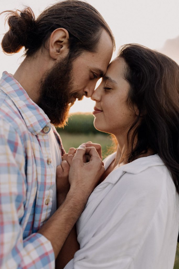 Couple is facing each other and touching noses. Hampshire photo shoot during golden hour. Natural and intimate moments during photo session. Hampshire photographer. Ewa Jones Photography