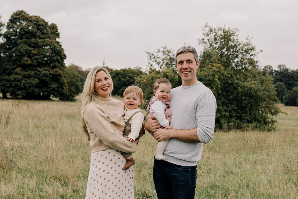 Family is standing in the nature common and looking at the camera. Lovely family photo session celebrating one year of twin babies. Natural family photo shoot. Hampshire and Surrey Photographer. Ewa Jones Photography