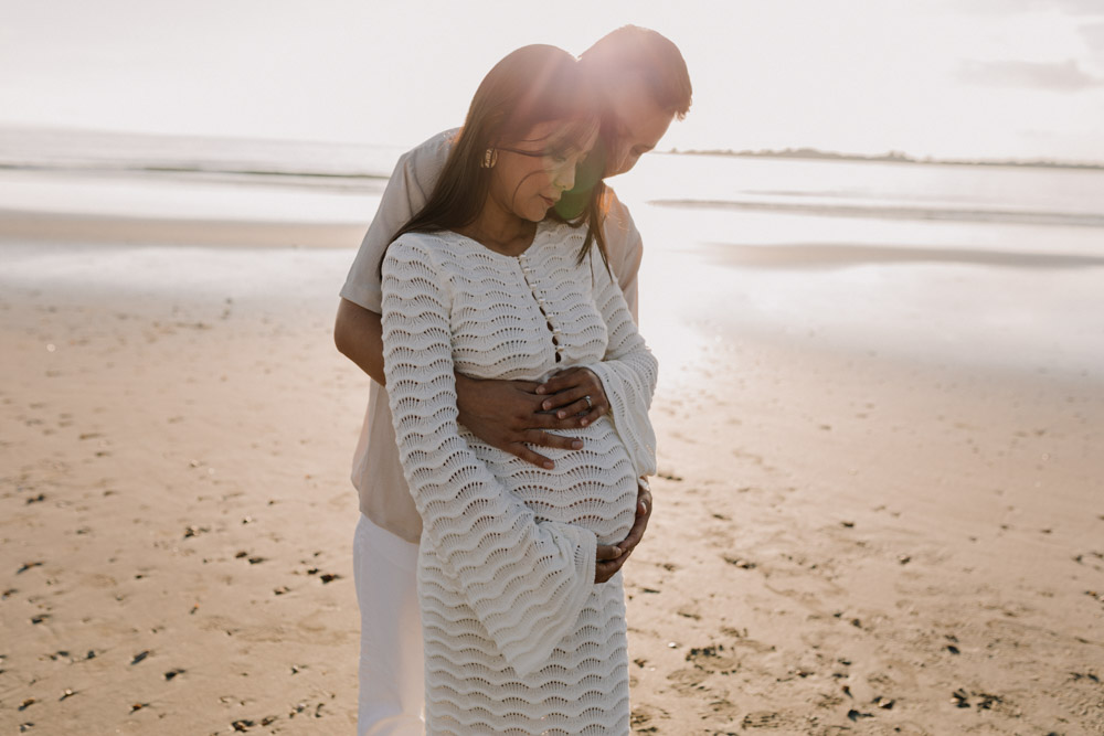 Lovely natural maternity photo shoot at the beach. Couple is standing and cuddling with each other. intimate photo session. Hampshire maternity photographer. Ewa Jones Photography
