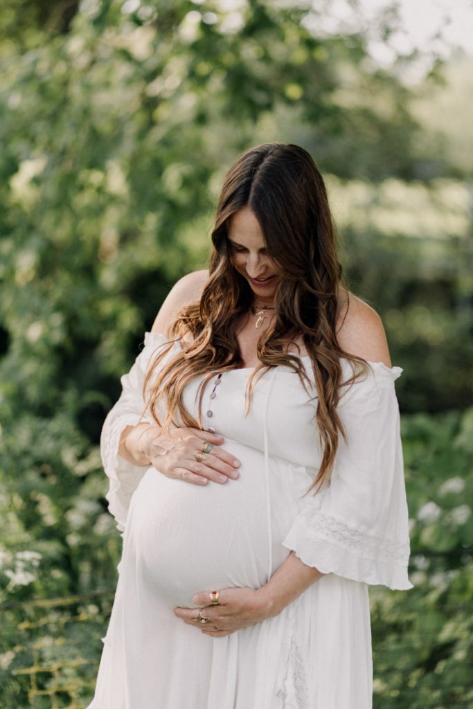 Mum is wearing beautiful flowy dress during her pregnancy photo session. Natural maternity photo shoot. Bump photo session in Hampshire. Ewa Jones Photography