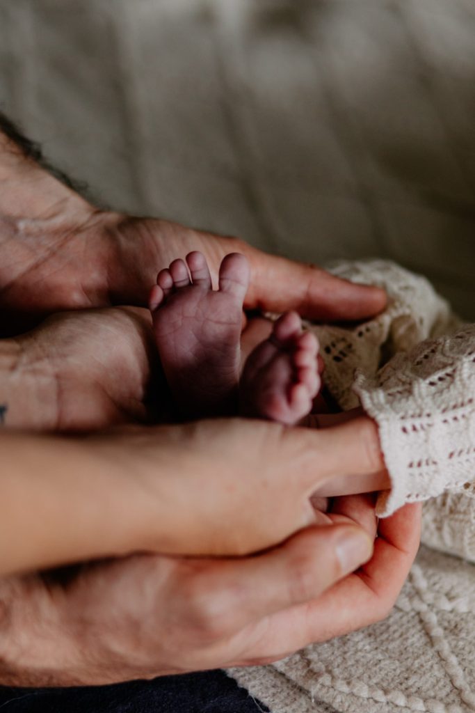both parents are holding newborn newborn baby feet. detail photo you must take during newborn photo session to remember lovely baby tiny details. Hampshire newborn baby photo session. Ewa Jones Photography