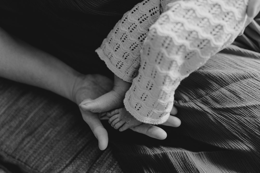 Close up image of newborn baby feet. Mum is holding baby's feet. Hampshire and Berkshire newborn photographer. Hampshire photo shoot at home. Ewa Jones Photography