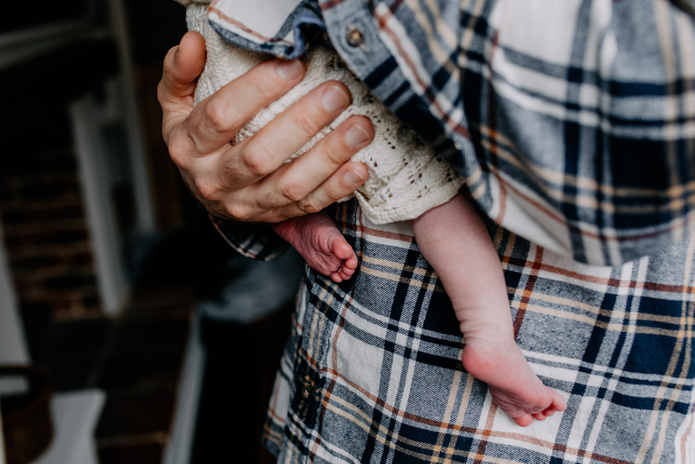 close up details of newborn baby feet. Dad is holding newborn baby. in home newborn session. Milestone package. Capturing maternity, newborn and one year old. Winchester newborn photo shoot. Ewa Jones Photography