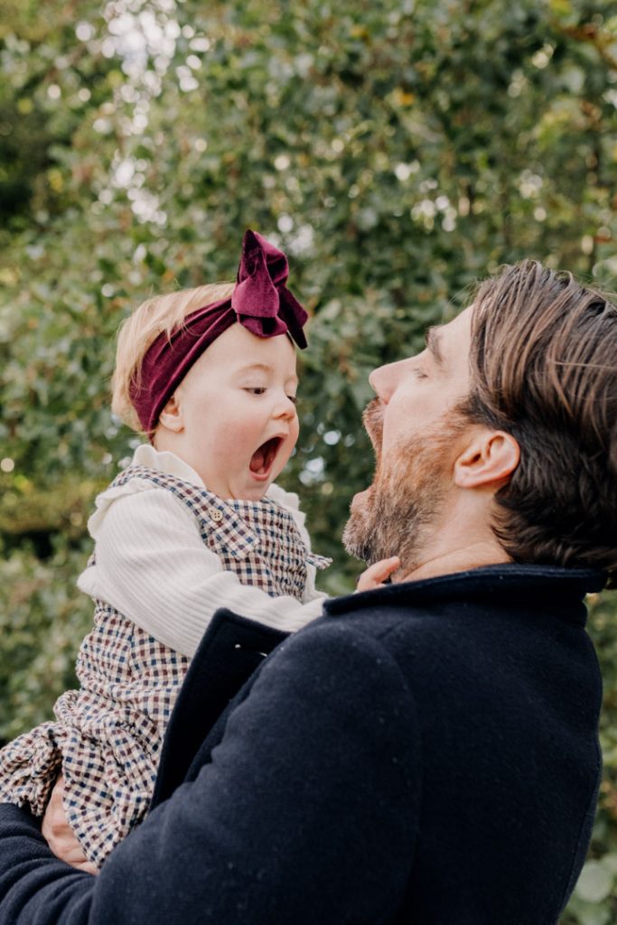 Daughter and dad are singing together. Great natural moment during family photo session. celebrating family. one year old photo session outside. Basingstoke family photographer. Hampshire photo shoot. Ewa Jones Photography