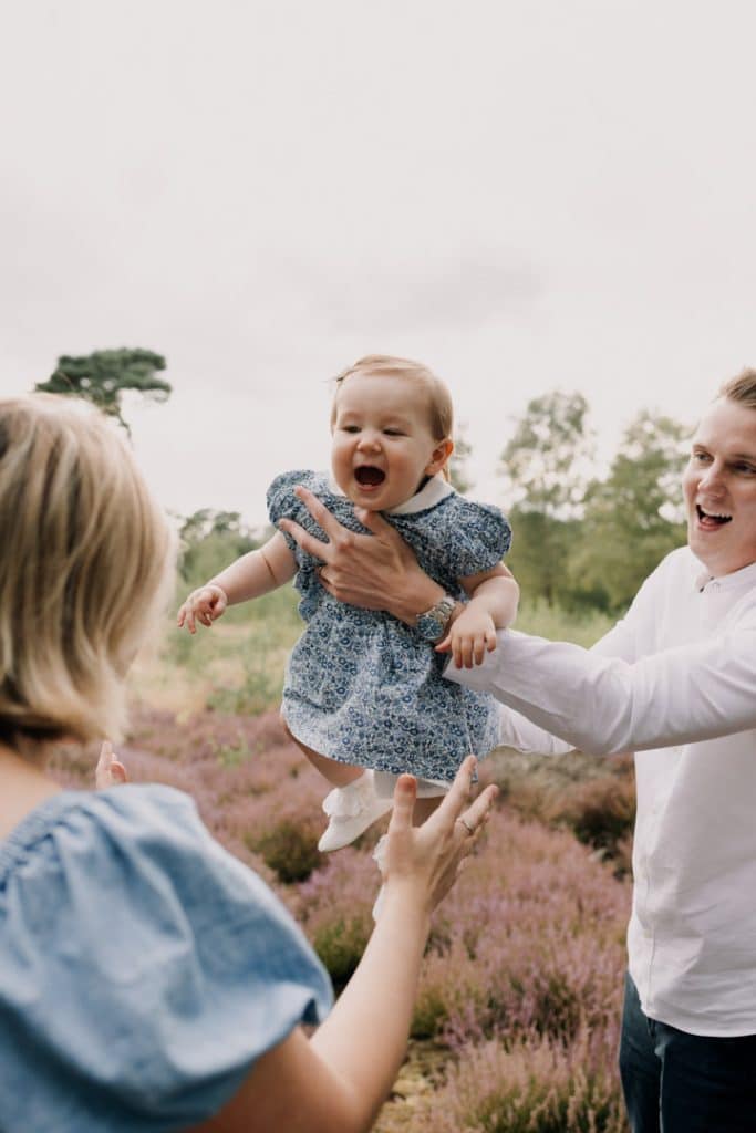 Dad is doing an aeroplane with his daughter. poses for family photo sessions. Lovely natural moment of family photo shoot. Lifestyle family photographer. Ewa Jones photography