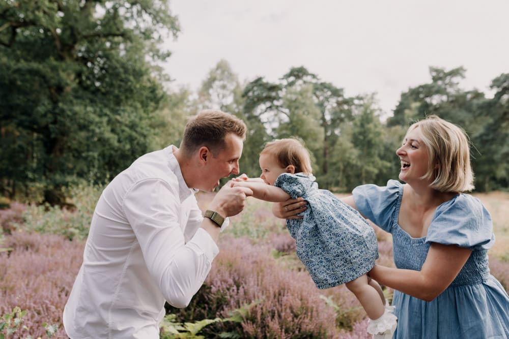 mum is throwing her baby girl towards dad's arms. Family poses for family photo session. Family photography in Berkshire. Hampshire photographer. Ewa Jones photography