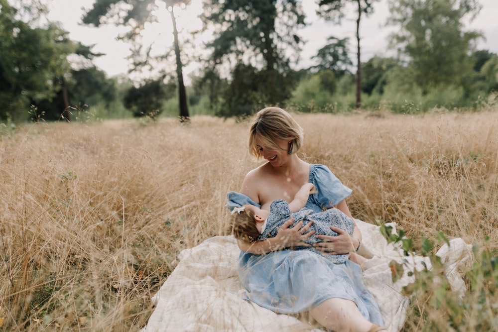 Mum is breastfeeding her baby girl outside. lovely images to remember. family photo session in Berkshire. Ewa Jones Photography