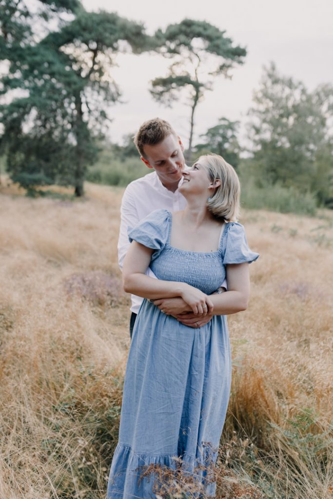 Mum and dad are standing in the field.intimate family photo session in Berkshire. Hampshire family photographer. Ewa Jones Photography