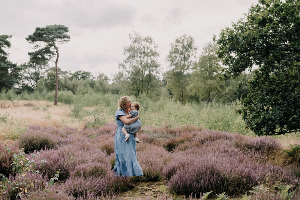 Mum is standing with her daughter in the nature common and kissing her forehead. Lifestyle photographer. Hampshire photo shoot. Ewa Jones photography