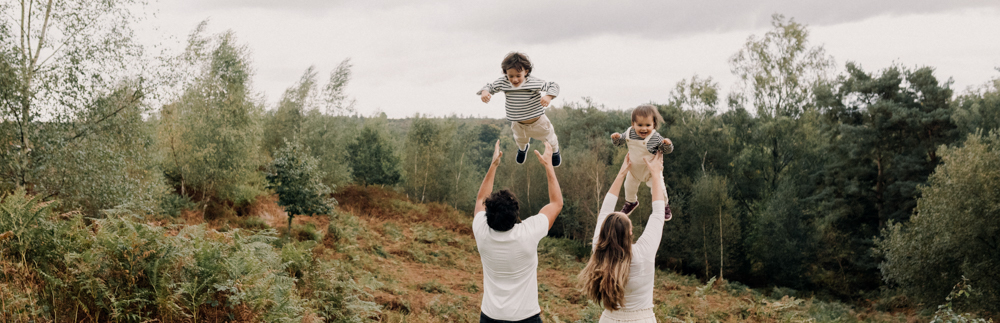 family is outside and mum and dad are lifting their boys in the air. natural family photography in Hampshire. Hampshire and Basingstoke family photographer. Ewa Jones Photography