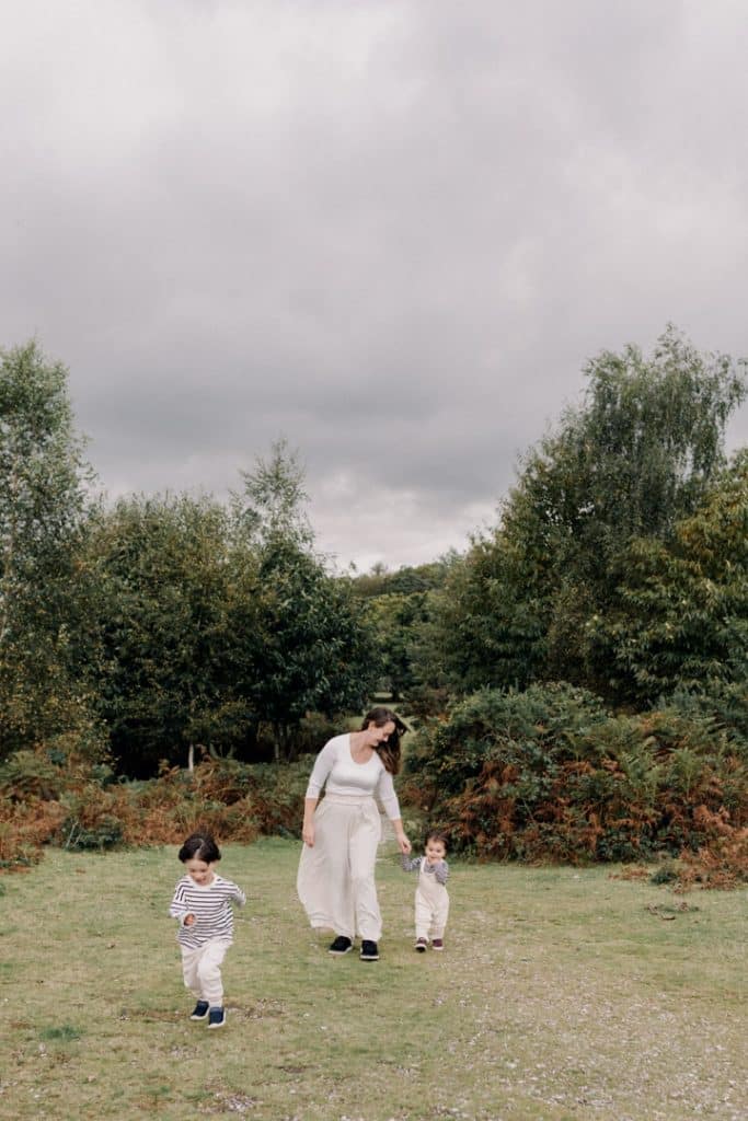 Mum is walking with her sons and holding hand with one son. Hampshire photo session. Ewa Jones Photography