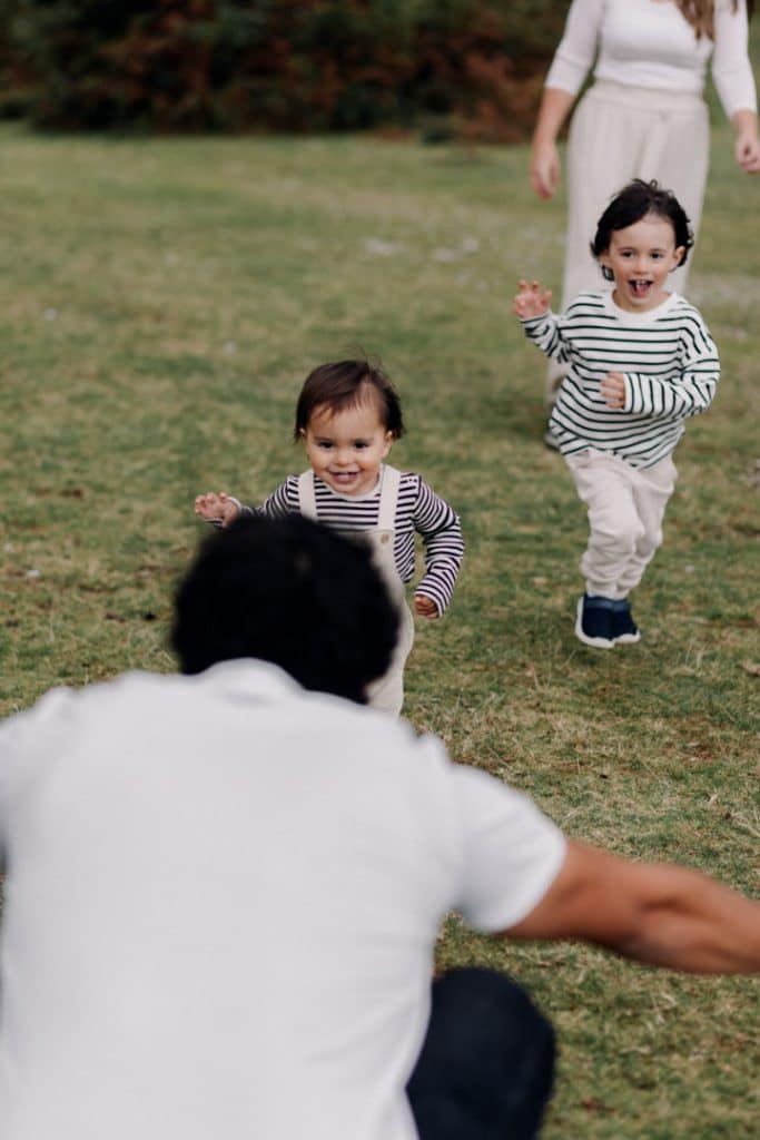 boys are running to his dad. playful natural family photo session. remembering new forest. lovely memories. Hampshire family photographer. Ewa Jones Photography