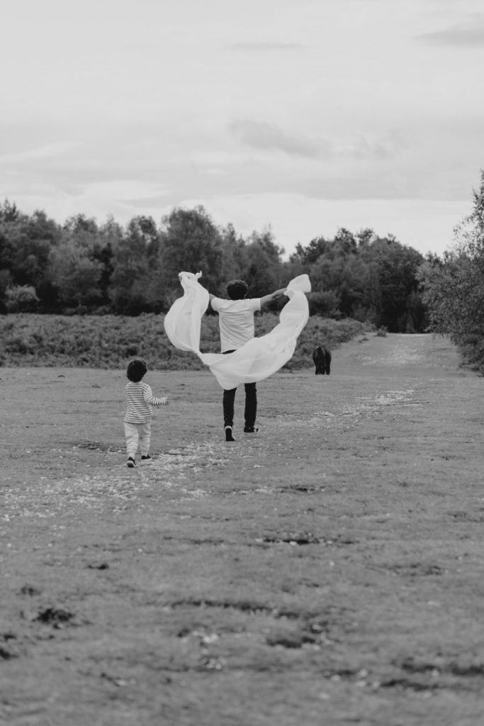 Dad is running away with the veil and his son is trying to catch him. family fun moments during family photo session. Basingstoke family photographer. Ewa Jones Photography