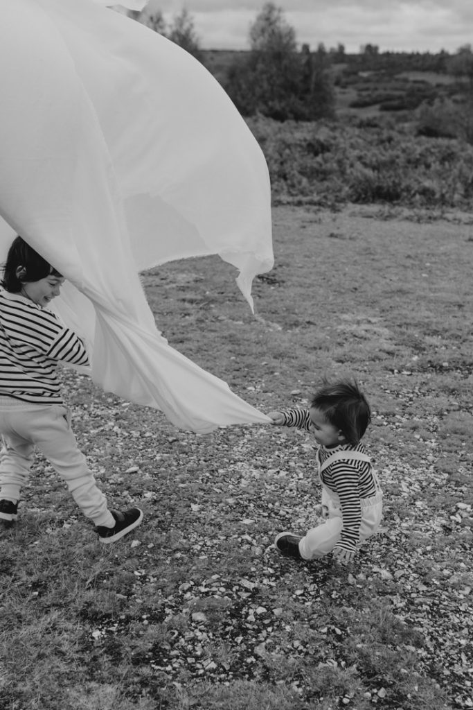 Boys are playing and trying to catch the veil. fun family time during Hampshire family photo shoot. Hampshire and Basingstoke photographer. Ewa Jones Photography
