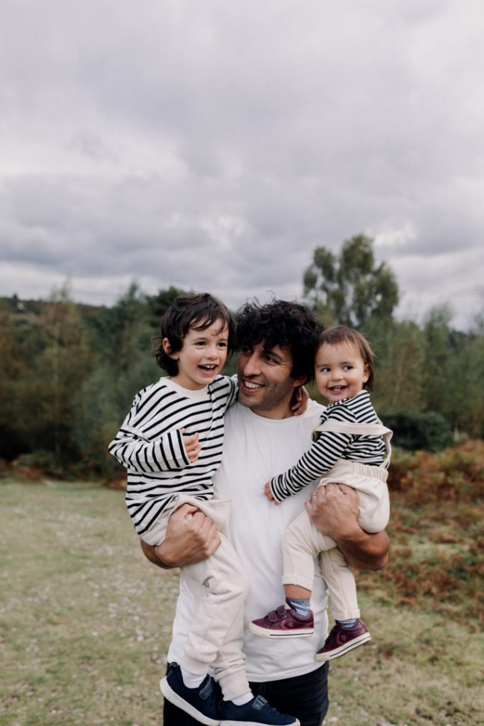 Dad is holding both of his sons and smiling to them. Boys are smiling too. fun and playful family photo session in Hampshire. Basingstoke and Hampshire photographer. Ewa Jones Photography
