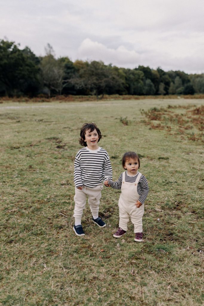 Brothers are standing in the field and holding hands. family photo session in the New Forest. Hampshire photographer. Ewa Jones Photography
