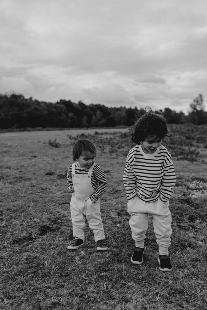 Brothers are coping each other and playfully putting their hands in the pockets. Family photo shoot in Hampshire. Family photographer. Ewa Jones Photography