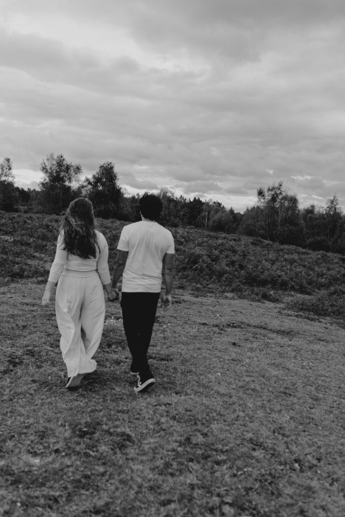 mum and dad are holding hands and walking away from the camera. black and white image. family photo session. Hampshire photographer. Basingstoke photographer. Ewa Jones Photography