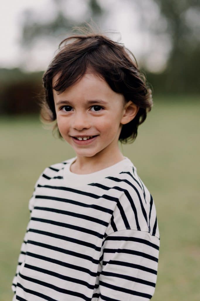 Boy is smiling and looking at the camera. lovely portrait photograph during a relaxed family photo session. Hampshire photographer. Ewa Jones Photography