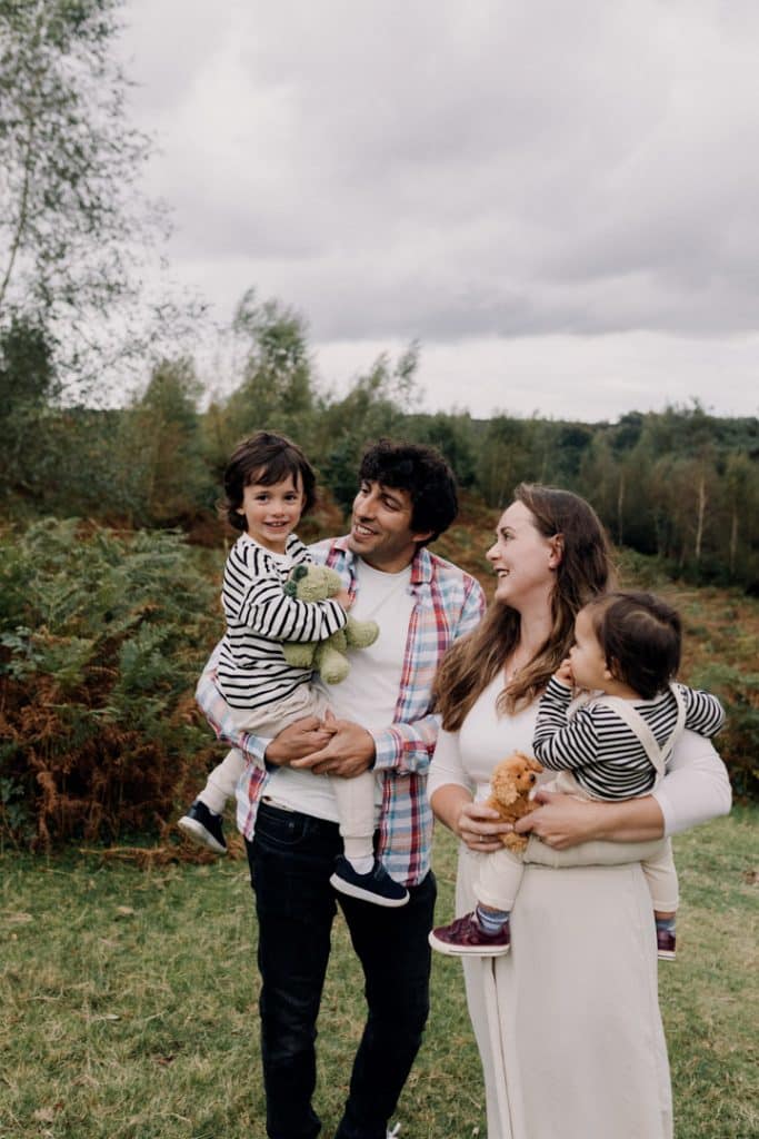 Family is cuddling close and smiling to each other. family photo shoot outdoors. Hampshire family photographer. Ewa Jones Photography