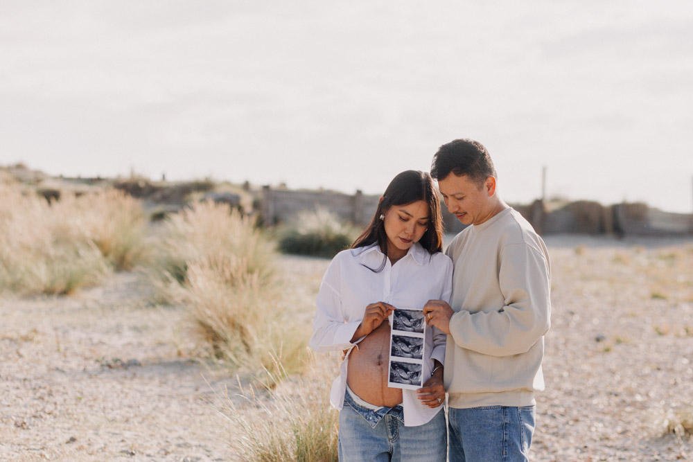 expecting parents are holding baby photo scan. maternity session at the beach. Hampshire maternity photographer. Ewa Jones Photography