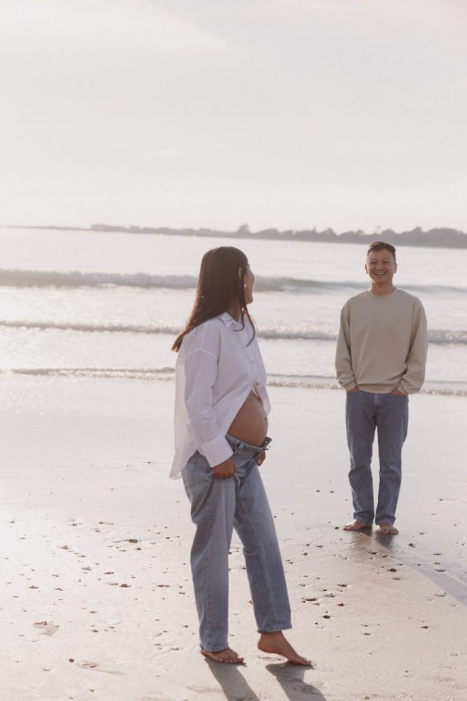 Wife is looking away and smiling to her husband. Husband is smiling back. natural photo session at the beach. Hampshire photographer. Ewa Jones Photography