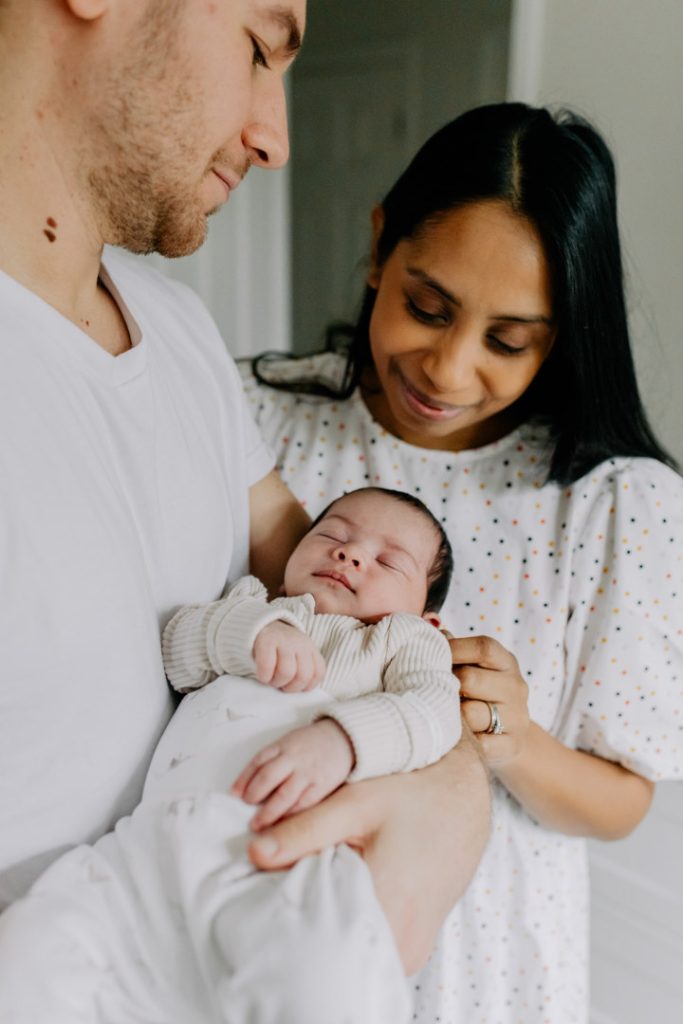 parents are looking at their newborn baby. Hampshire newborn photo shoot. natural in home session. Hampshire photographer. Ewa Jones Photography