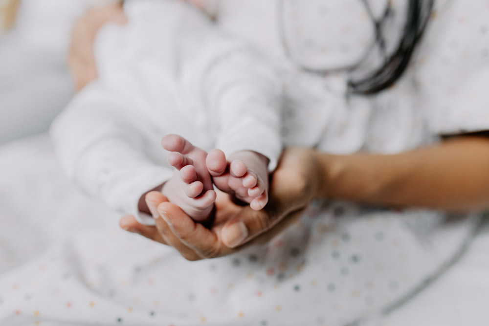 mum is holding baby's feet. Details during newborn photo shoot. Hampshire photo session. newborn photographer. Ewa Jones Photography