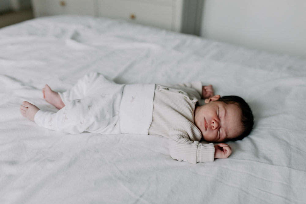 baby is sleeping and laying on the bed. Newborn photography in Hampshire. Ewa Jones Photography