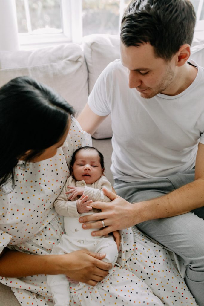 Parents cuddling their newborn baby during an in-home newborn photo session in Hampshire. Ewa jones Photography