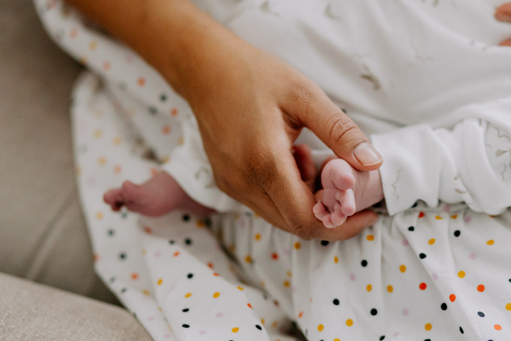 close up of mum holding newborn baby foot. tiny details. newborn photo session in Hampshire. In home newborn photo shoot. Ewa Jones Photography